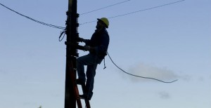 Un operaio al lavoro su un traliccio